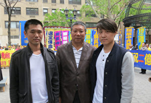 2015年5月15日，两位大陆年轻人在纽约集会现场公开宣布退出中共党团队之后，与美国守护者同盟主席卞和祥（中）合影。（林南／大纪元）