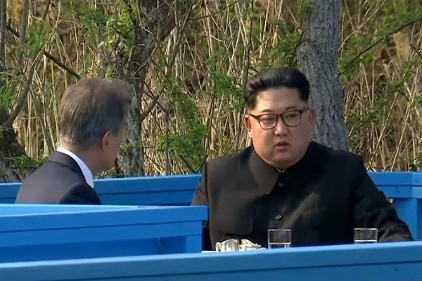 4月27日，韩国总统文在寅与朝鲜领导人金正恩在池畔一旁板凳上坐下来谈。(视频截图) 